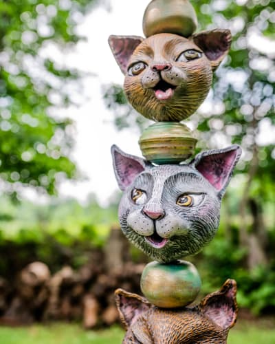 Centre d’Art Rozynski - A sculpture outdoors features a stack of cat heads separated by spheres.