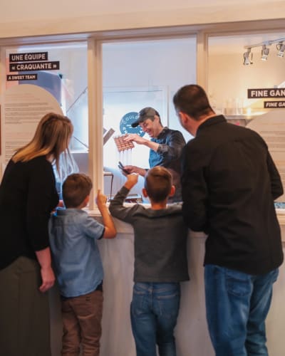 Famille observant un chocolatier à l'oeuvre.