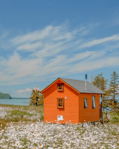 Tiny house orange au bord du fleuve au printemps. 