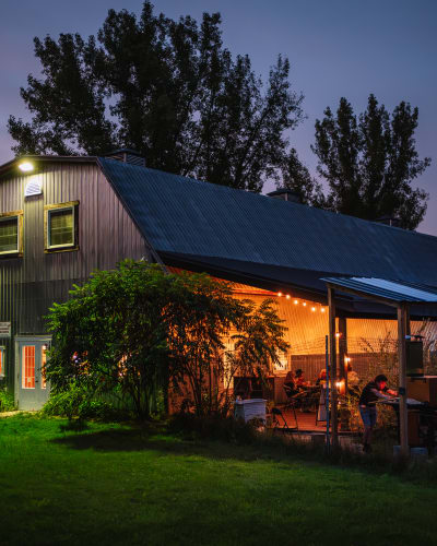 Domaine Ives Hill - Une bâtisse avec une terrasse illuminée en soirée