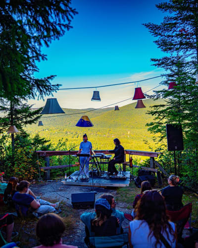 Concert au belvédère : public assis, abat-jours et vue sur la vallée
