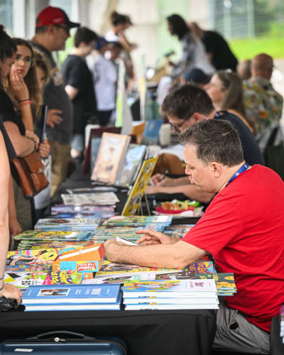 Prévost Comic Arts Festival - Cartoonists sitting at tables meet people