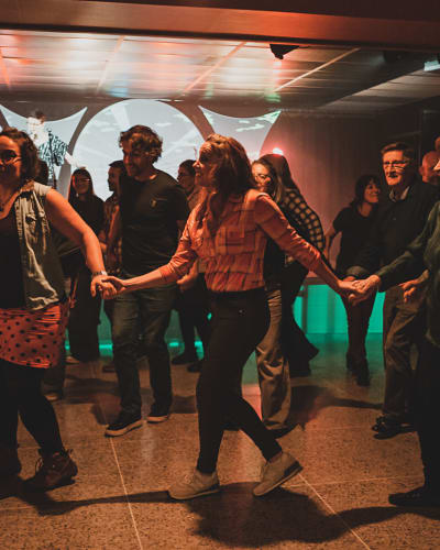 Val-d'Or Traditionnal Music Festival - People dance in a line, holding hands.