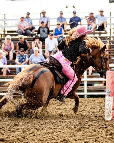 Femme faisant une course de barils au Festival Western de Guigues.