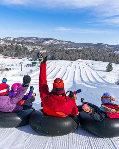 Famille aux glissades sur tube du Sommet Saint-Sauveur.