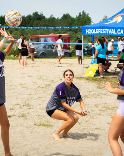 3 jeunes femmes jouant au volleyball.