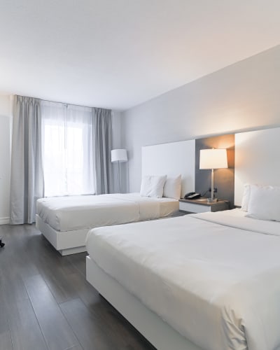 Une chambre avec deux lits doubles à l'Hôtel Universel Québec.