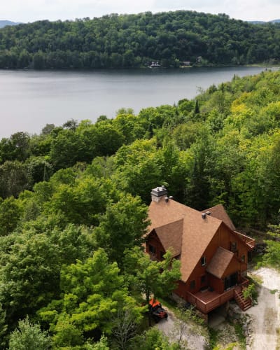 Aerial view of a cabin near a lake in summer.