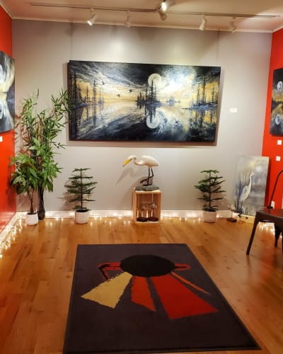 La Galerie de Miss Rey exposant des tableaux de paysages et d’oiseaux.