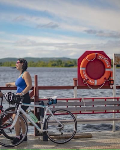 Une homme et une femme sont debout sur le bord de l'eau, avec leur vélo à leur côté