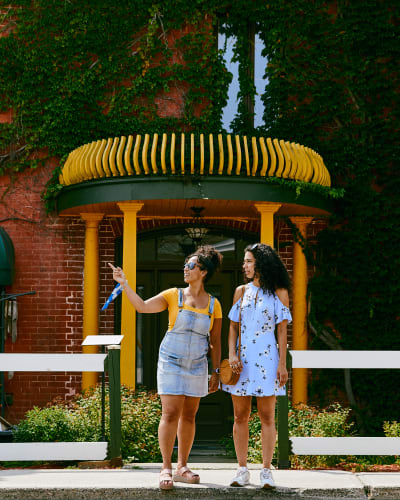 The artists and artisans of Montebello - Two individuals are standing on a sidewalk, looking in the same direction.