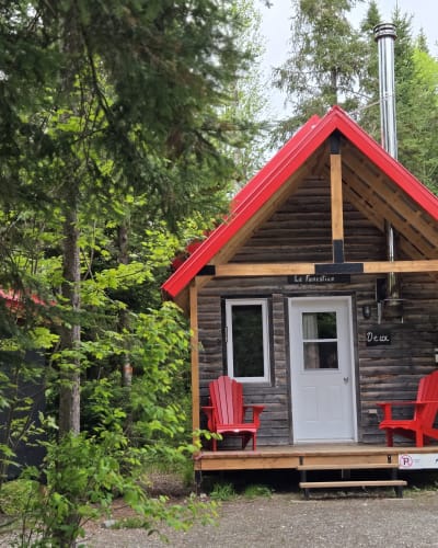 Micro-Chalets des Appalaches - Petit chalet avec deux chaises rouges sur le balcon