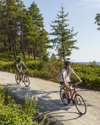 Parc national de la Pointe-Taillon - Un homme et une femme font du vélo en nature