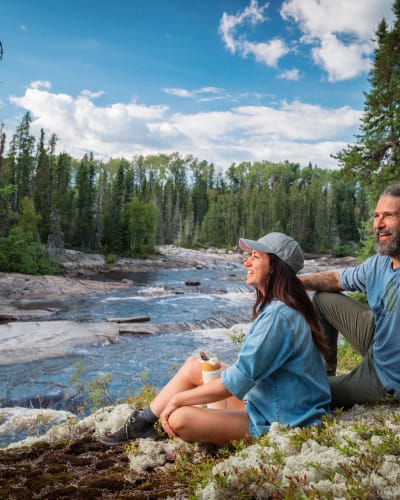Homme et femme assis sur le bord de la rivière en été. 