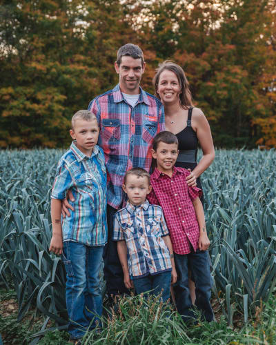The Therrien family of Potager Therrien in a field at dusk.