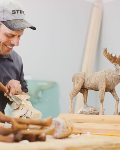 Wood sculptor and wooden moose.