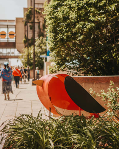 Sculpture en oiseau sur un trottoir. 