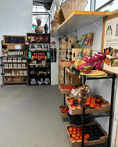 Kiosque intérieur avec produits et tomates en vente. 