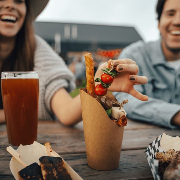 A couple at a table with beer and a meal.
