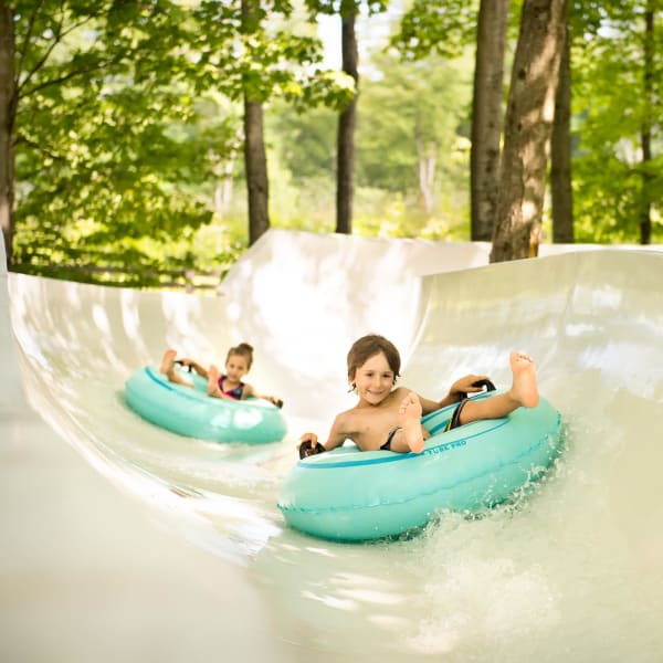 Children on tubes in a water slide.