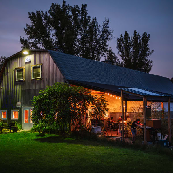 Domaine Ives Hill - Une bâtisse avec une terrasse illuminée en soirée