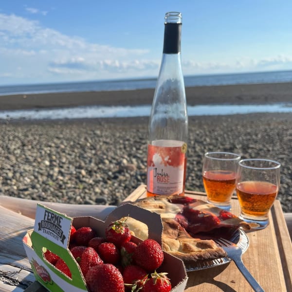 Produits et vin de fraises sur le bord de mer.