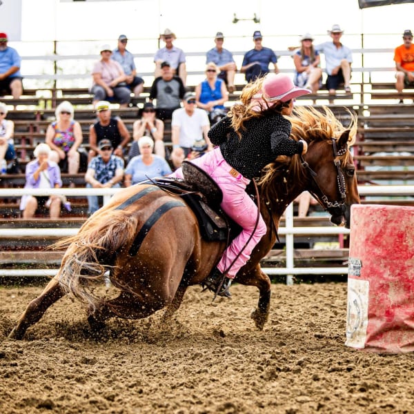 Femme faisant une course de barils au Festival Western de Guigues.