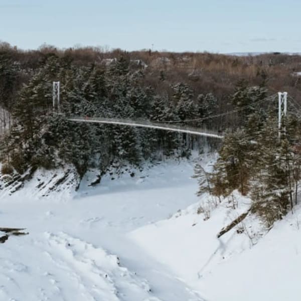 Vue aérienne de la passerelle au-dessus de la rivière en hiver.