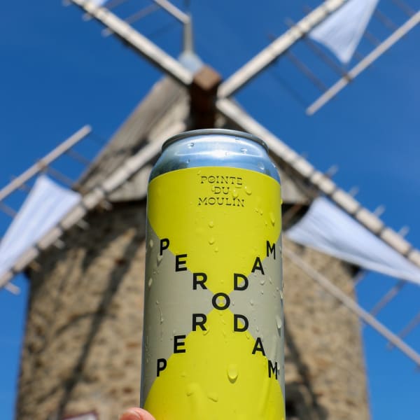 Perodam Microbrasserie Solidaire - Cannette de bière, un moulin en arrière-plan.