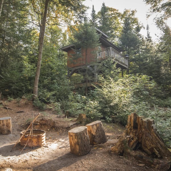 Cabane perchée et feu de camp.