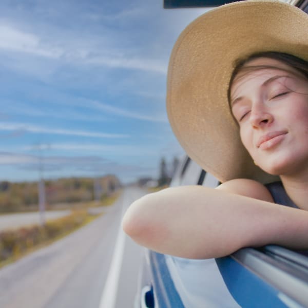 Route touristique Tour du lac Saint-Jean - Une femme est dans une voiture en mouvement, la vitre baissée et profite du vent