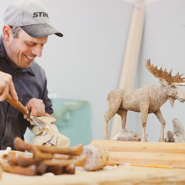 Wood sculptor and wooden moose.