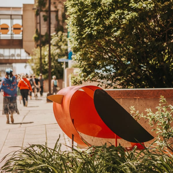Sculpture en oiseau sur un trottoir. 
