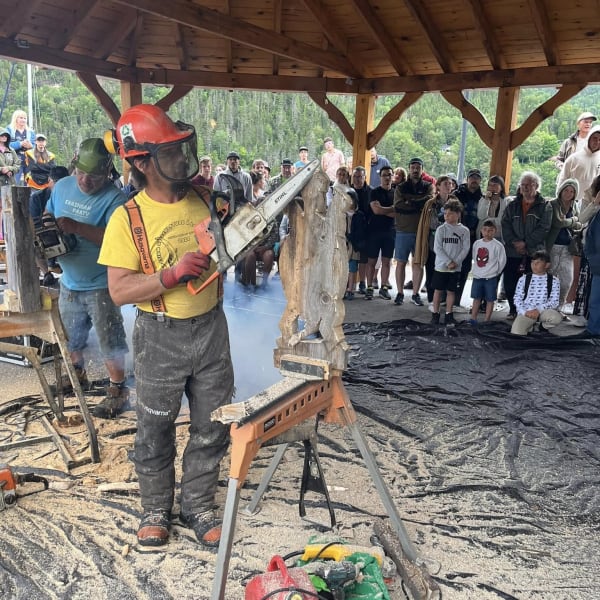 Symposium de sculpture à la tronçonneuse - A man creates a wood sculpture with a chainsaw