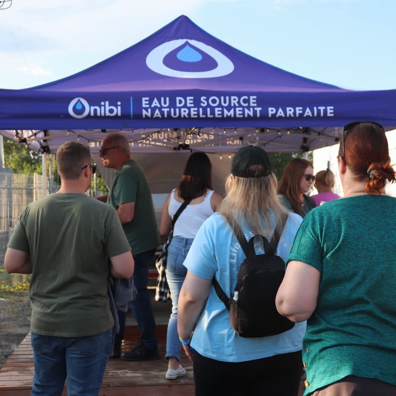 Festivalier·ères en ligne pour avoir de l'eau au H2O Festival.