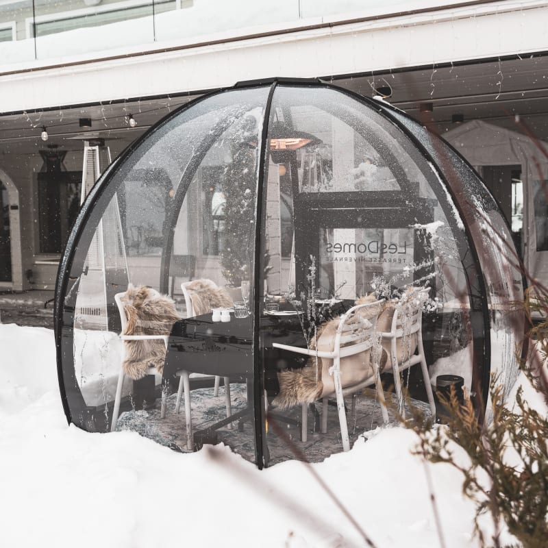 Table dans un dôme transparent en hiver au Bistro Koz. 