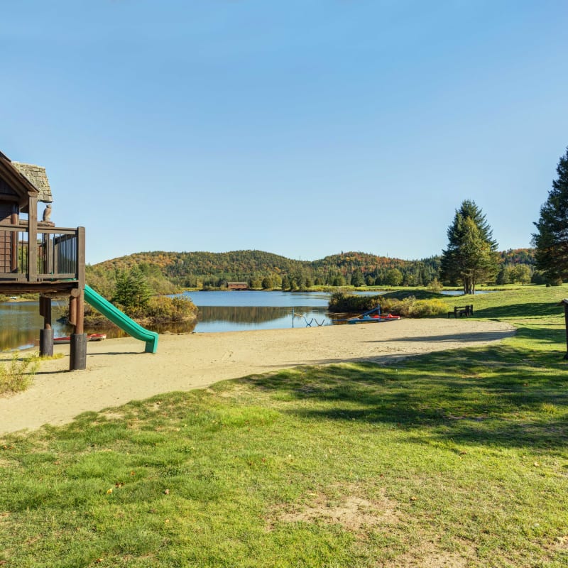 Parc pour enfant au bord d'un lac aux Chalets Royal Laurentien.