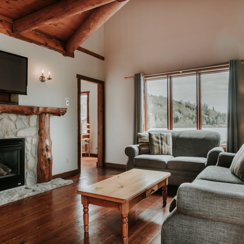 Salon avec divans et foyer dans un des Chalets Royal Laurentien.
