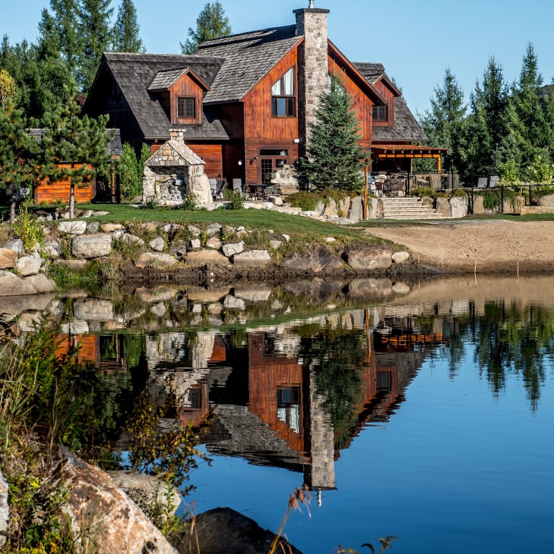 Extérieur d'une grande maison en bois et pierre aux Chalets Royal Laurentien.