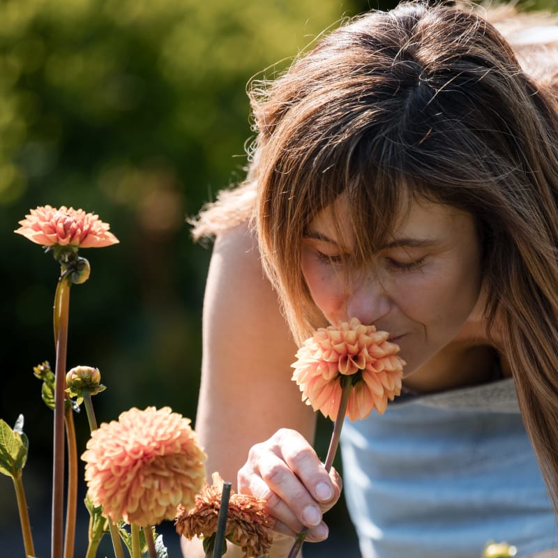 Adolescente sentant une fleur. 