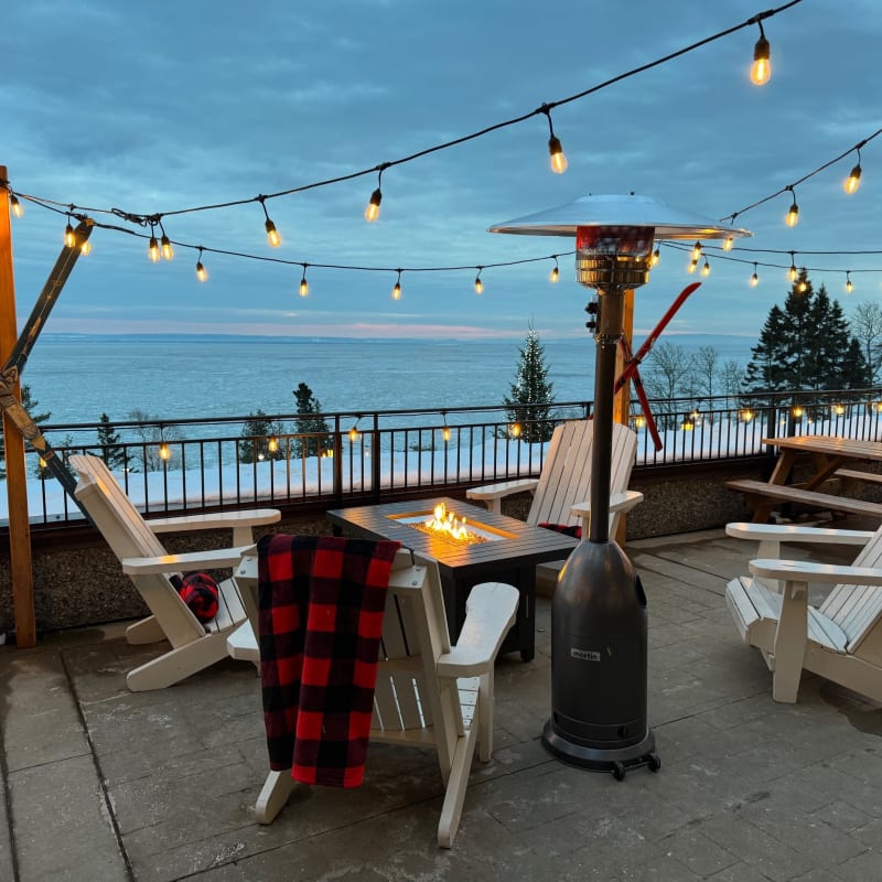 Terrasse hivernale du Manoir Richelieu, avec chaises, couvertures et foyer extérieur.