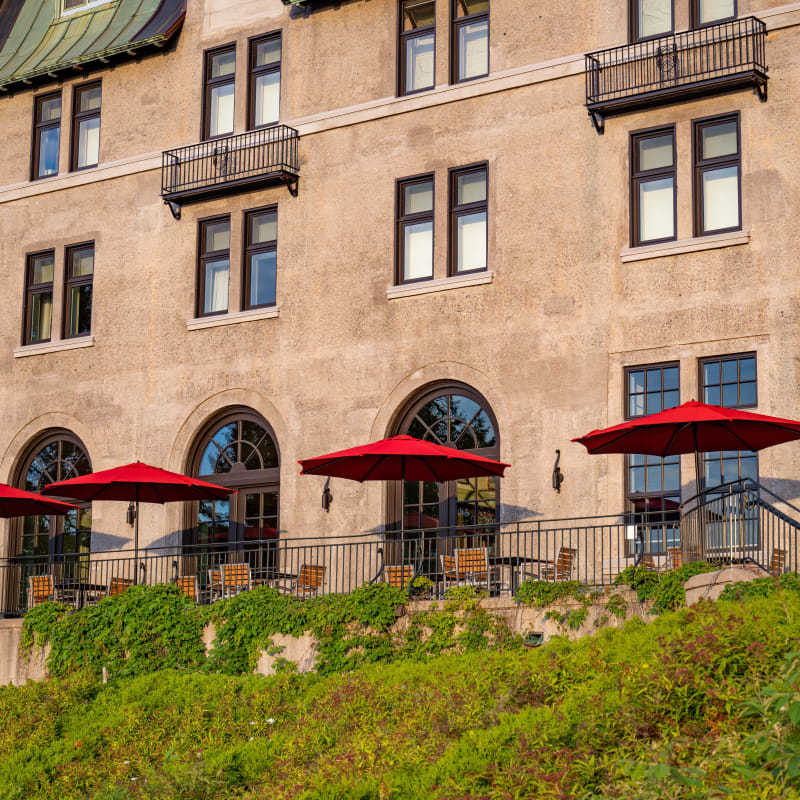 Terrasse avec plusieurs parasols rouges au Fairmont Le Manoir Richelieu.