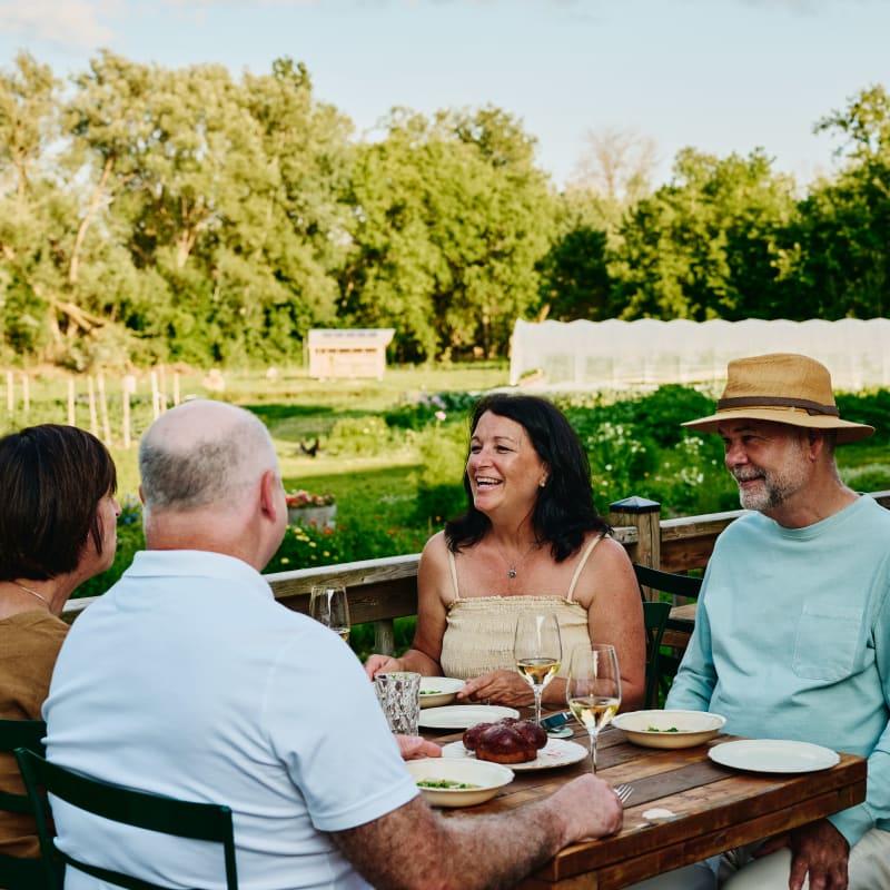 Quatre personnes attablées sur une terrasse par une belle journée d’été à l'Espace Old Mill.