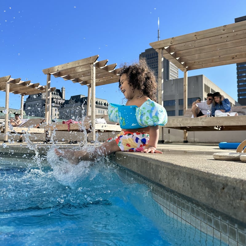 Petite fille au bord de la piscine extérieure au Hilton Québec.