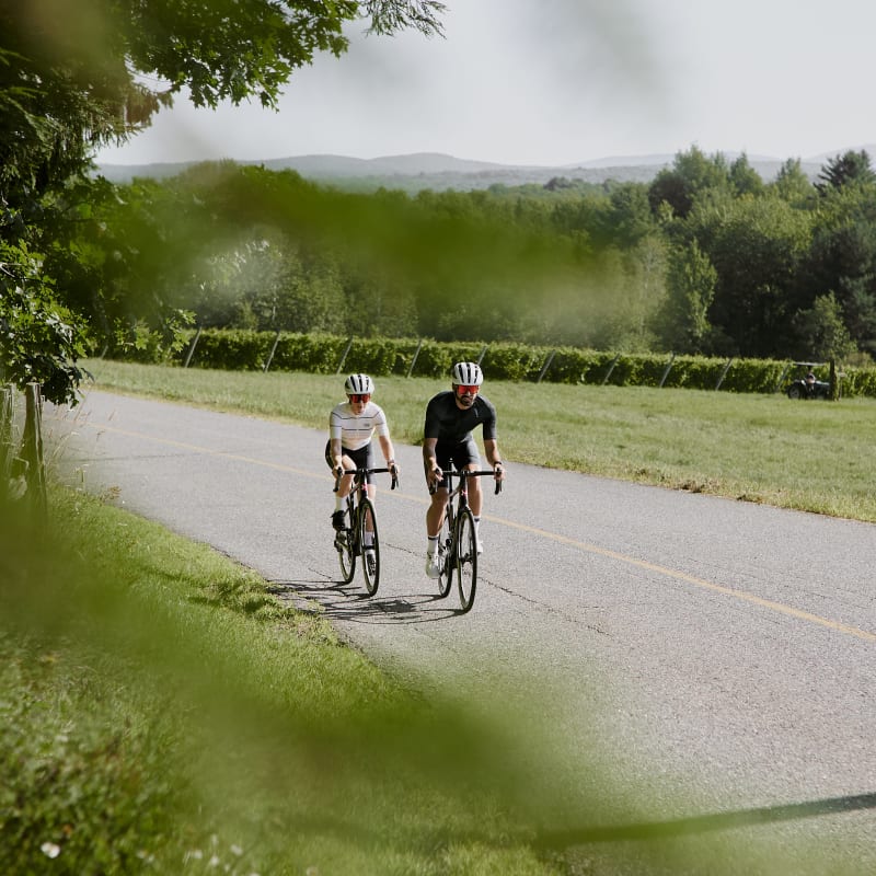 Deux personnes en vélo sur une route asphaltée.