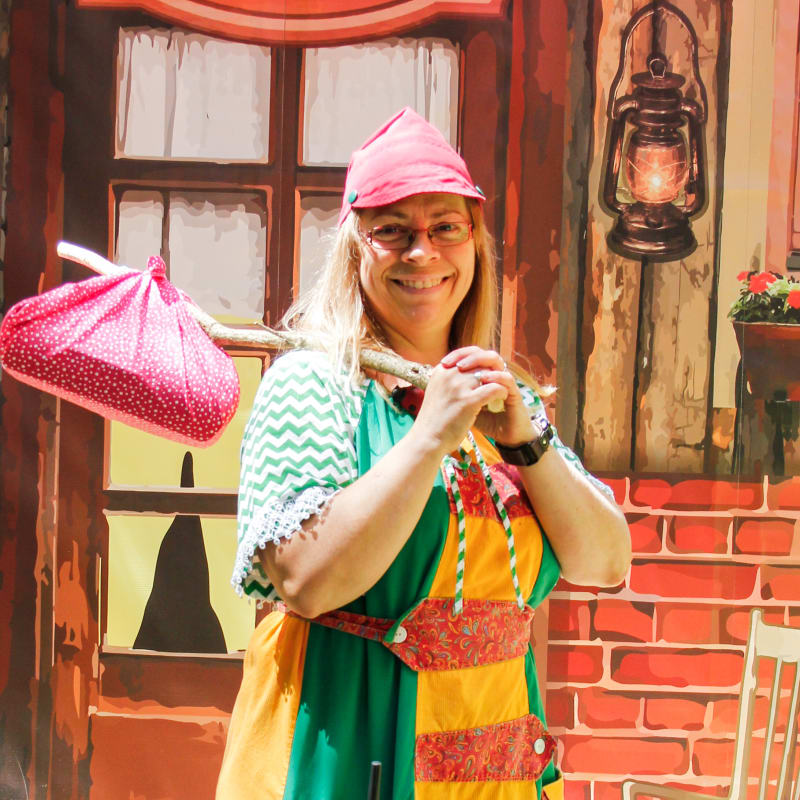 Femme avec un baluchon et un costume ludique à la Vallée Secrète.