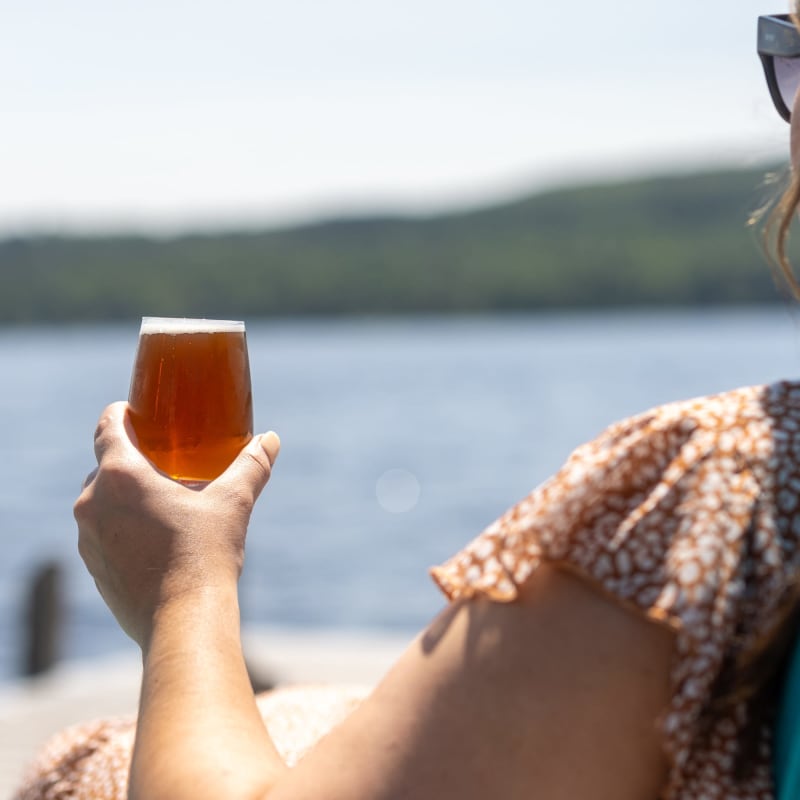 Woman with a beer by the lake.