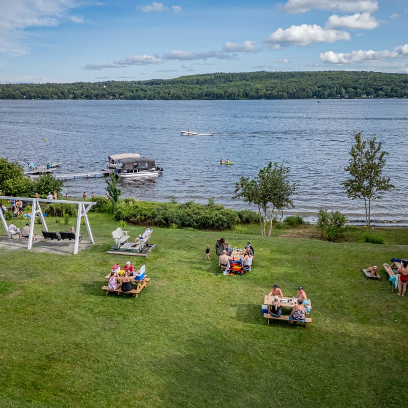Groups of people sitting by the water at Manoir Lac-Etchemin.