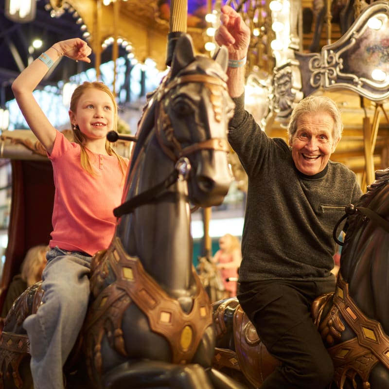 A little girl and a man on a carousel.