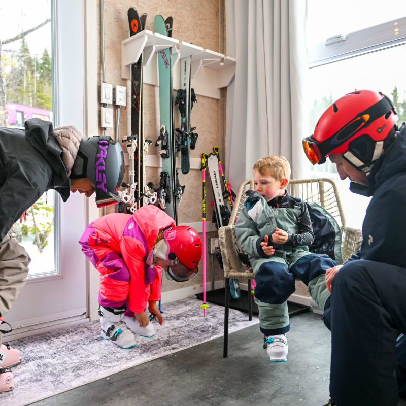 Famille en train de s'habiller pour le ski dans un hébergement Coolbox au Mont Grand-Fonds.